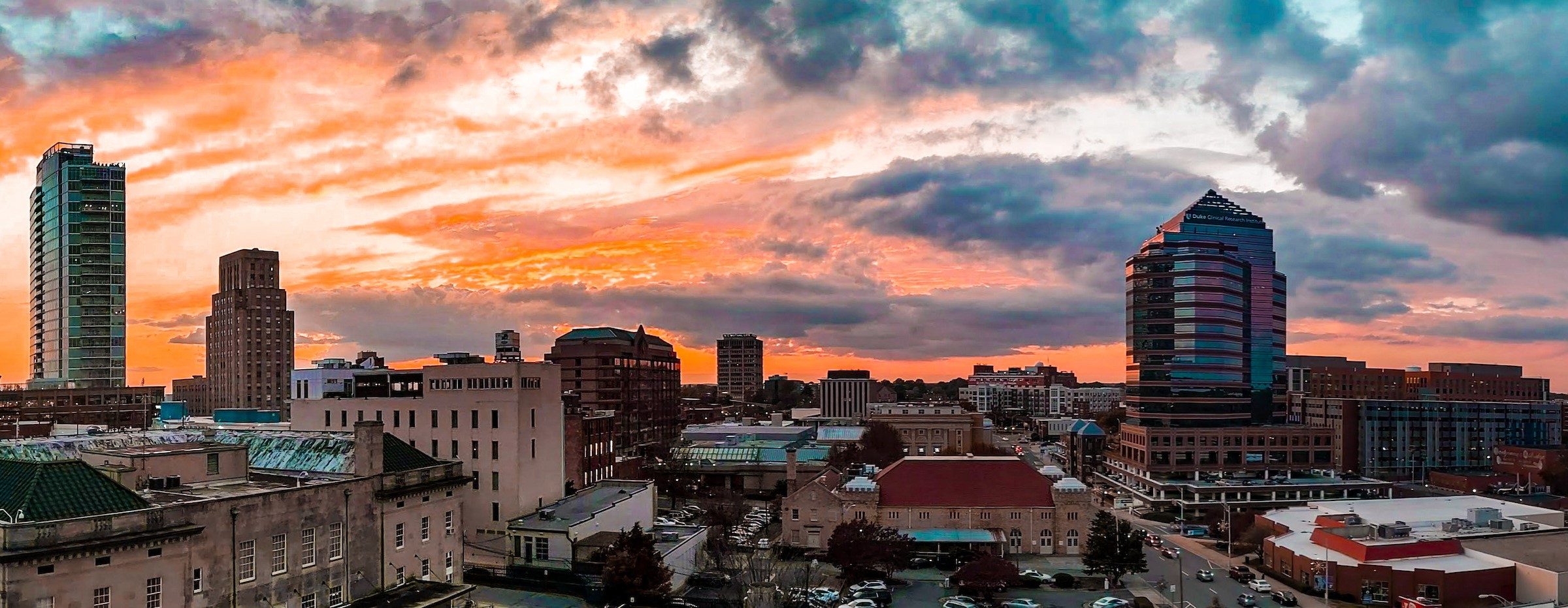 College students working together in library with computers and books on table.