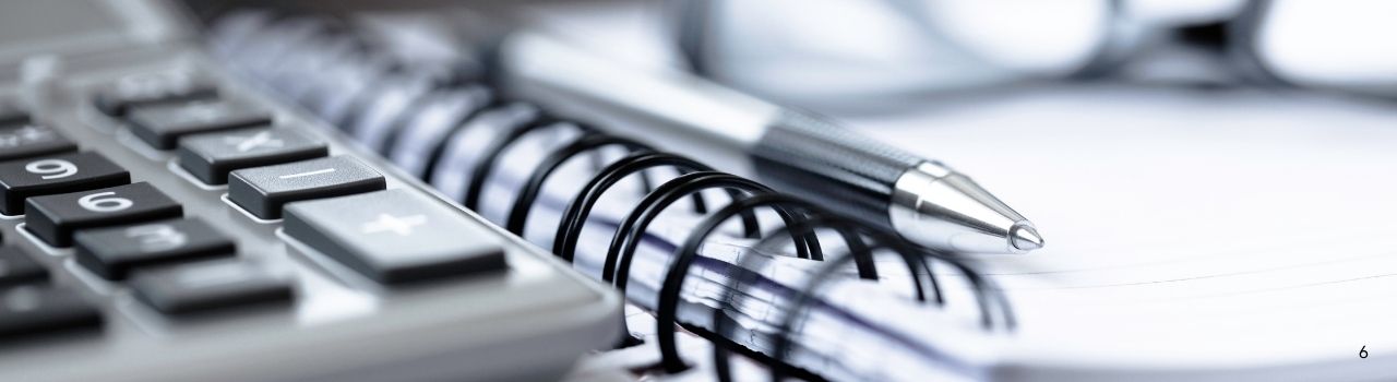 Notebook, calculator, pen on desk.