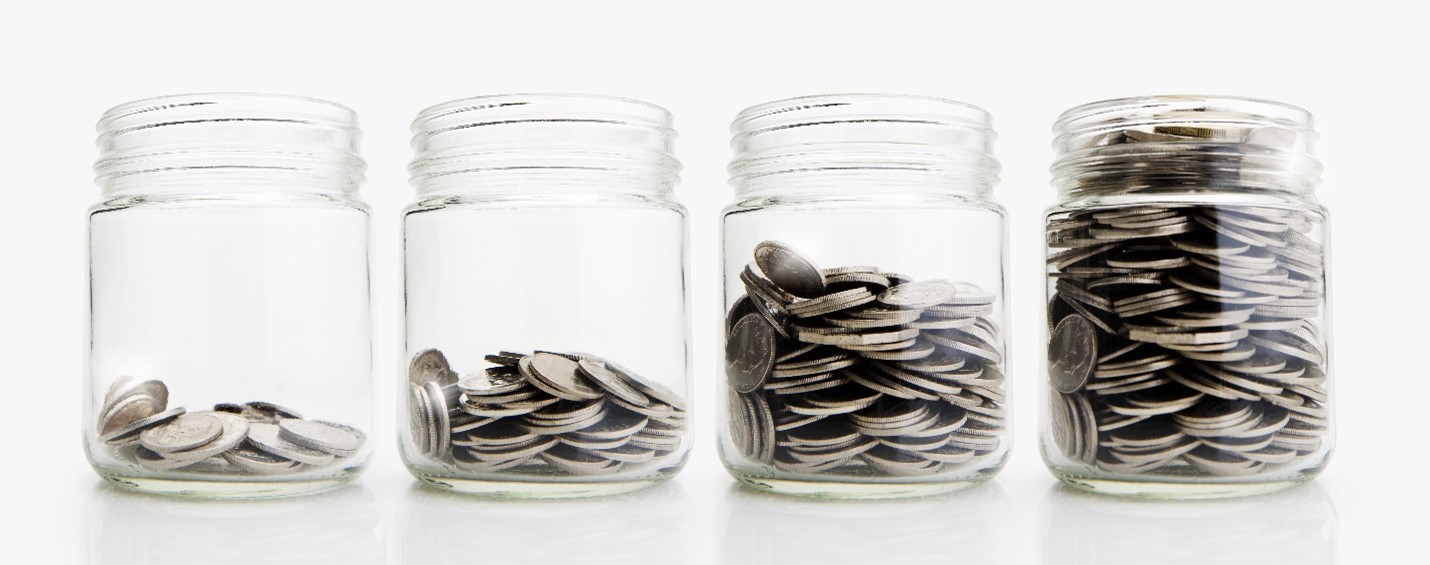 Four coin jars; from left to right with increasing amounts of coins
