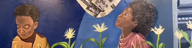 painted mural of two small children, a little boy is reading and a little girl is looking up into the night sky