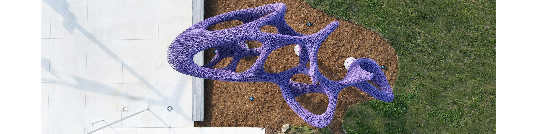 Aerial view of large purple modern sculpture in the shape of a cloud