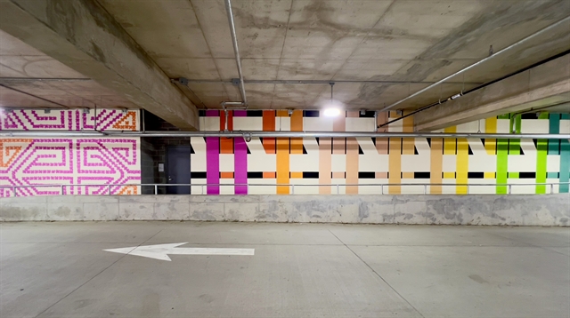 photograph of a long mural which shows different textile patterns in hot pink, orange, green, blue and purple