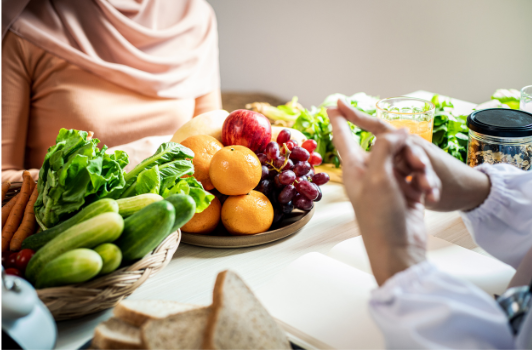 Two people talking with food on the table between them