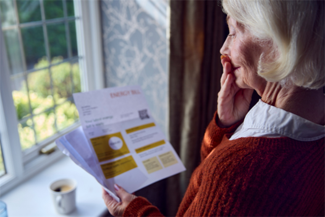 elderly woman looking at bill