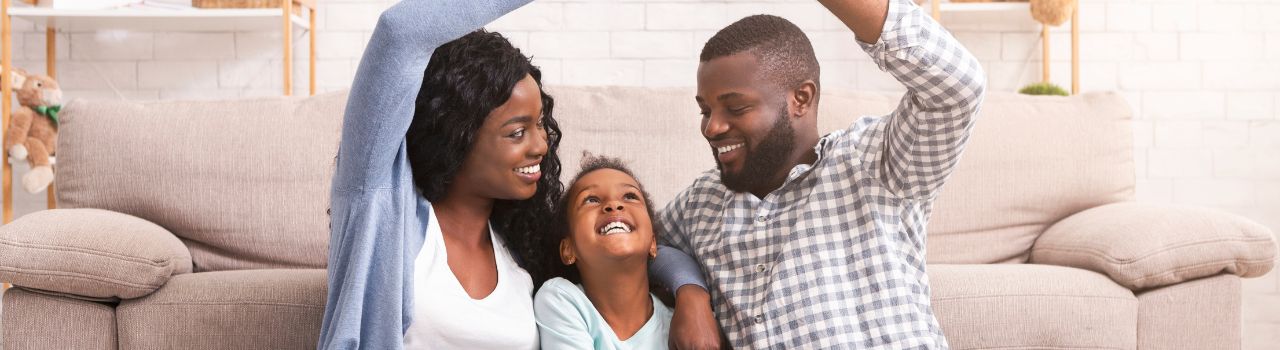 Young family with adopted child, sitting in living room.